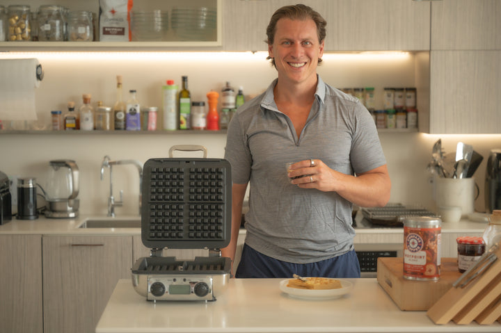 Michael Haft, CEO of Compass Coffee, in a modern kitchen with Waypoint blend coffee and kitchen gadgets.